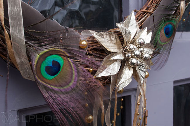 Peacock feathers Christmas wreath on purple door